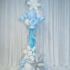 Blue and white winter balloon column with snowflakes, silver starburst balloons, fringe and a clear bubble topper.