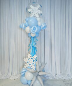 Blue and white winter balloon column with snowflakes, silver starburst balloons, fringe and a clear bubble topper.