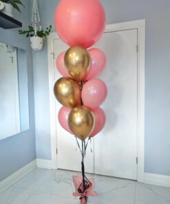 Blush and reflective gold helium balloon bouquet featuring an oversized pink jumbo balloon.