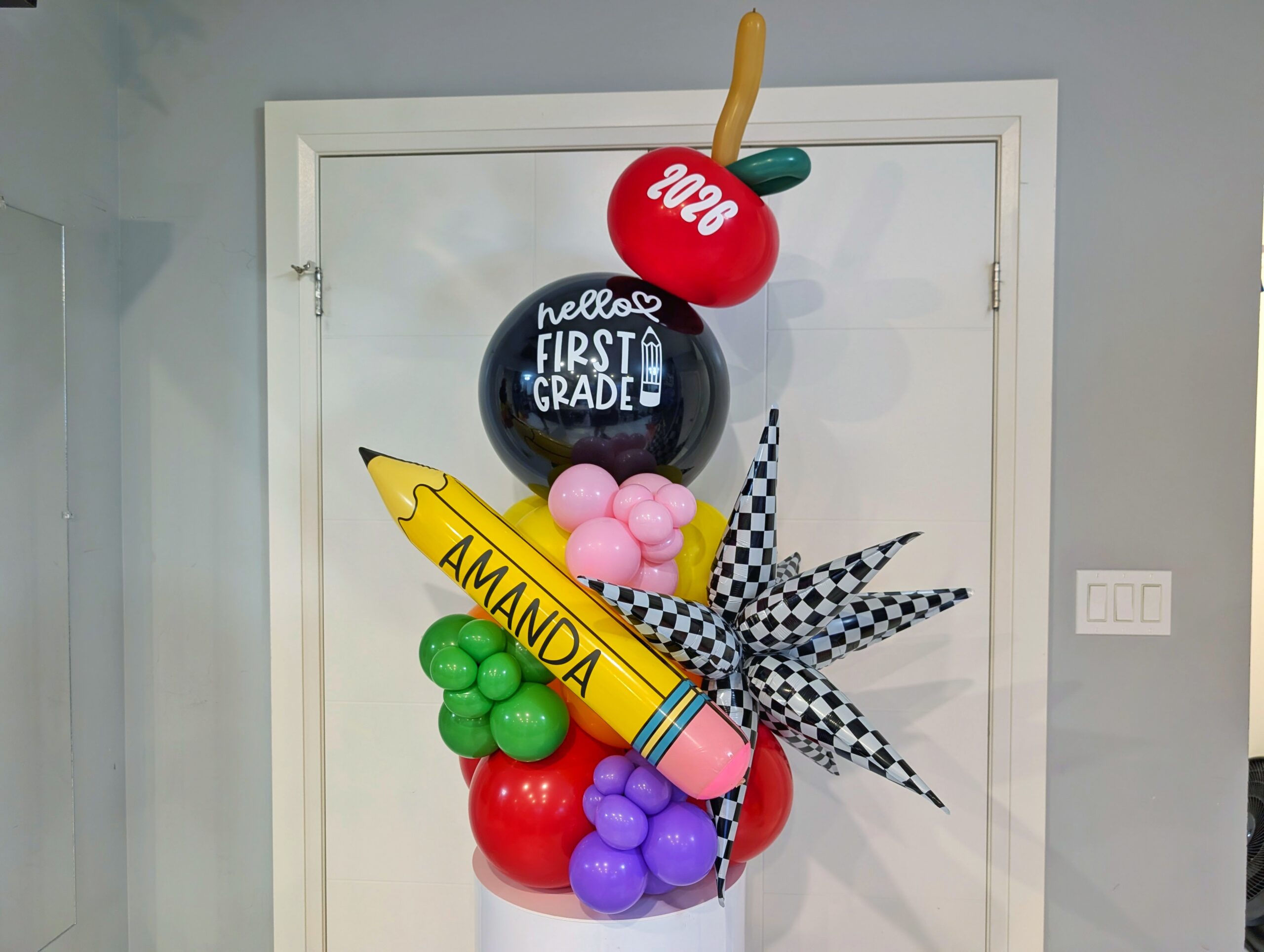 Personalized first-day balloon table topper with custom pencil, grade balloon, apple and colourful accents.