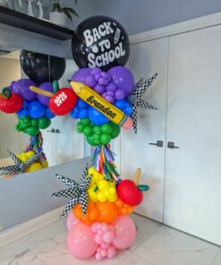 Rainbow Back-to-School balloon column with apples, starbursts, tassels and a personalized pencil.