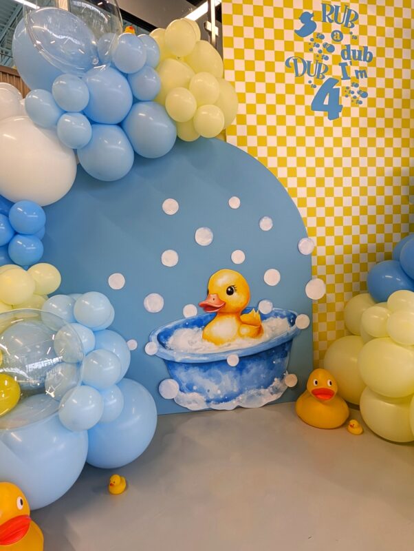 Custom Rub-a-Dub-Dub birthday backdrop with a duck bathtub illustration and bubble balloons.