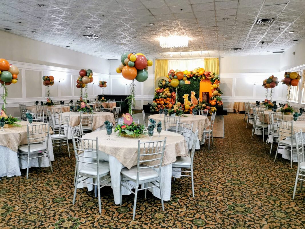 Lion King baby shower décor filling a Mississauga banquet hall with balloons, greenery and styled tables