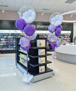 Purple and lavender helium bouquet with a clear bubble balloon containing a large white foil flower.
