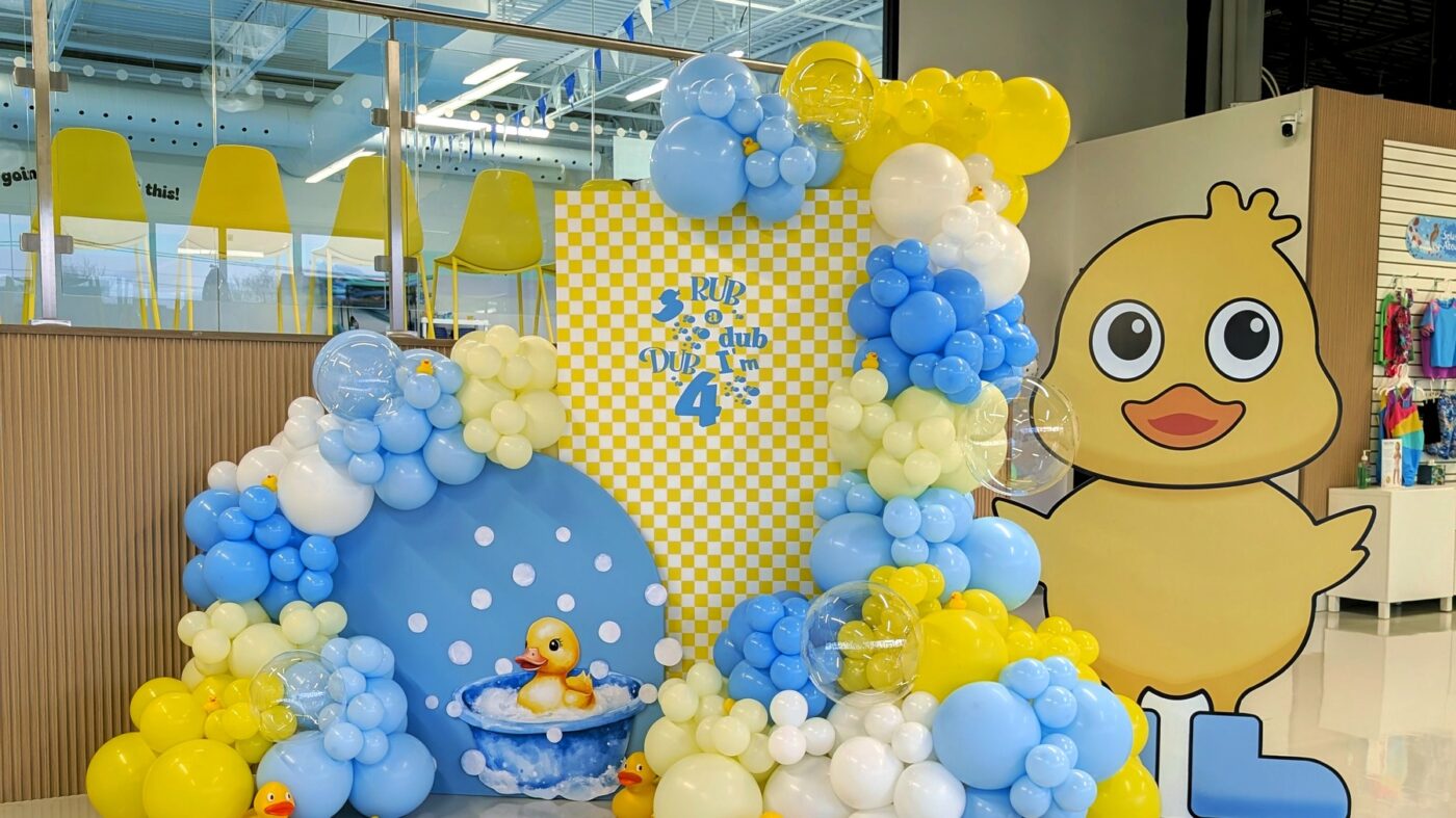 Rubber duck birthday backdrop with colourful balloons and a large custom duck cutout in Kitchener.