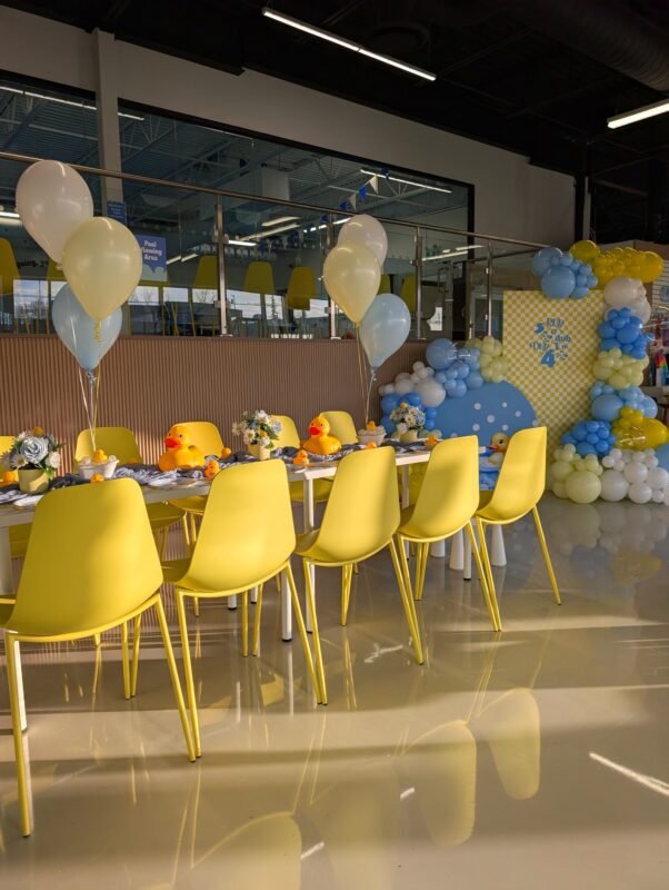 Rubber duck birthday table styling with soft balloon bouquets and a custom backdrop behind it.
