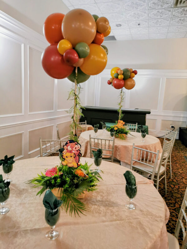 Safari floral centrepiece and elevated balloons with the Lion King props.