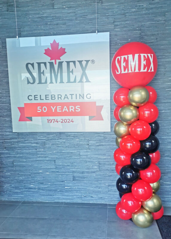 Semex 50th anniversary wall sign beside a red, black and gold balloon column in the Guelph office