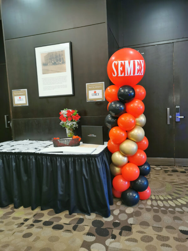 Branded Semex balloon column beside an event table at the corporate anniversary celebration